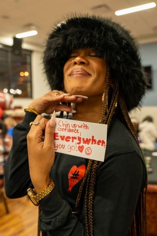 A guest holding an encouragement card at a community event