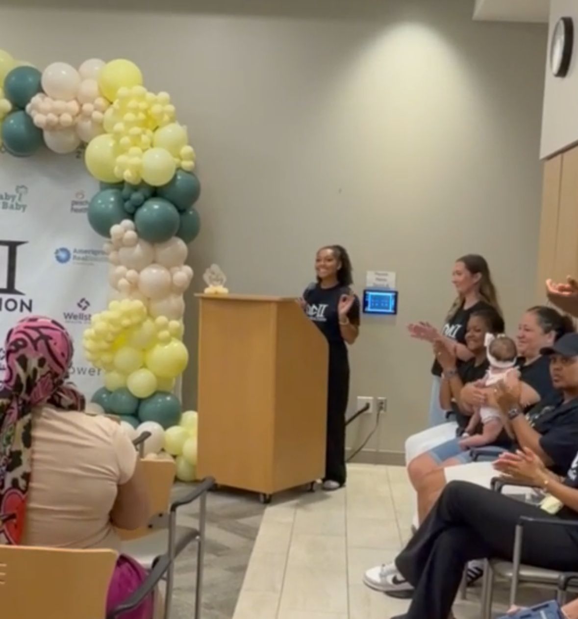 A program launch with community members applauding