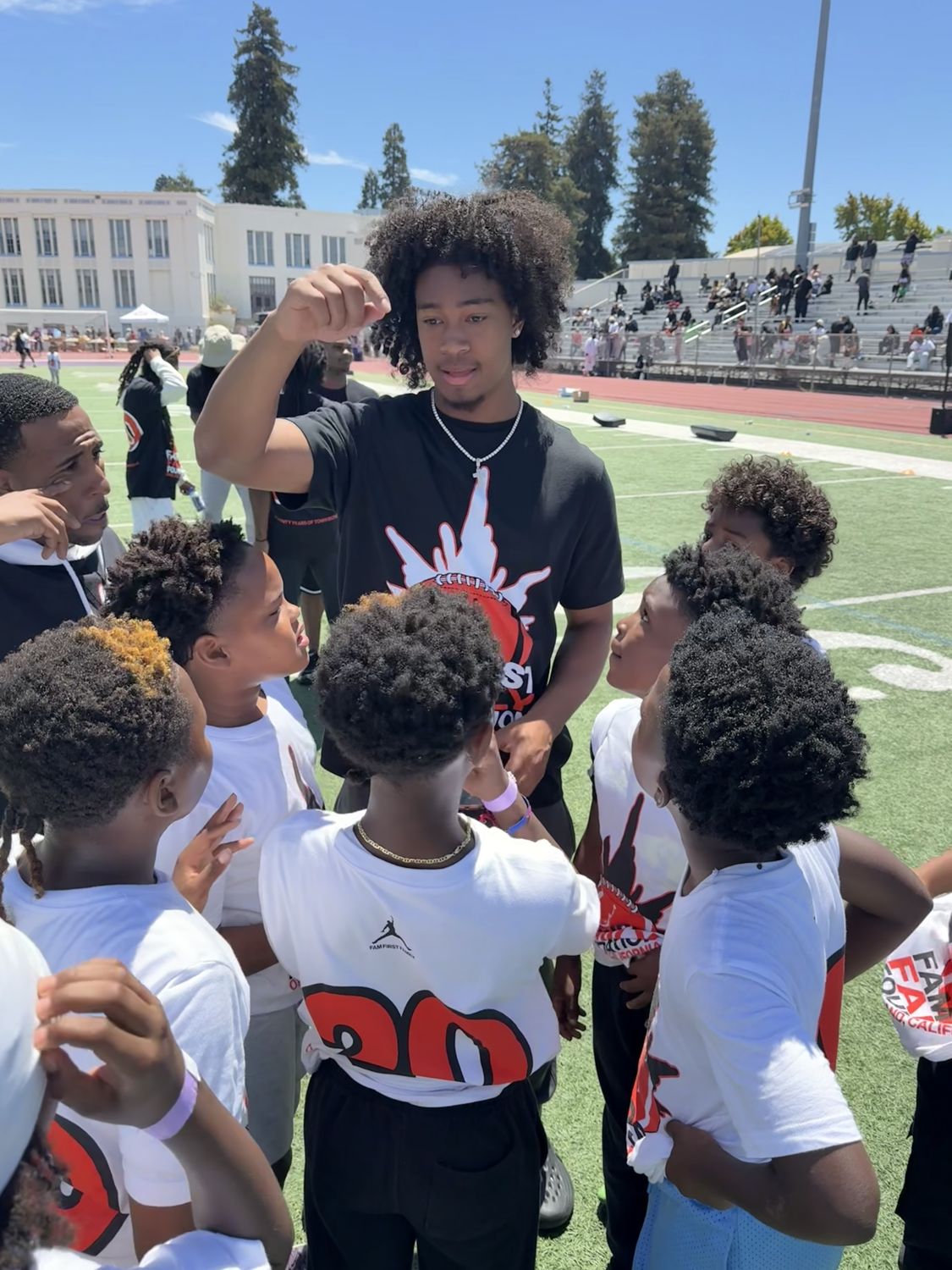 An athlete coaching a huddle of young players